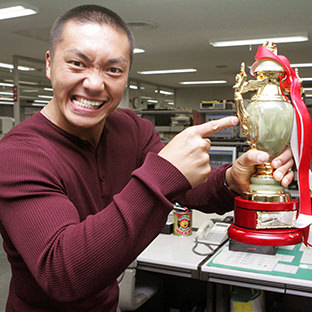 CIMA来社、本紙堀内取締役（右）からプロレス大賞のトロフィーを受け取るＣＩＭＡ