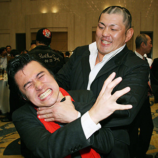 アントニオ小猪木の首を絞める鈴木みのる(右)