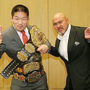 自身の保持するベルトを石井慧(左)に持たせる武藤敬司