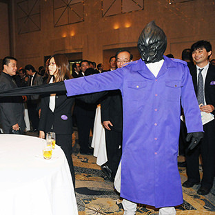 ゴム人間(右)と握手する高木三四郎