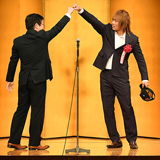 東スポ酒井社長（左）とロスインゴベルナブレスデハポン式の挨拶をする技能賞・内藤哲也