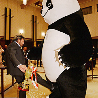 ジャイアントパンダに金的蹴りをいれるケニー・オメガ(左)