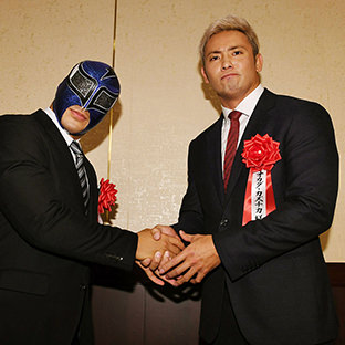 ストロングマシーン・J握手するオカダ・カズチカ（右）