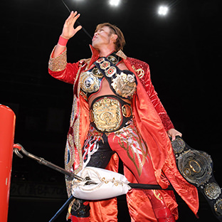 旧・三冠ベルトを身体にかけ、左手に新・三冠ベルトを持ってアピールする宮原健斗