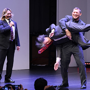 棚橋弘至(左)と木谷高明氏にボルチンシェイクをかけるボルチン・オレッグ