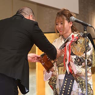 西村誠司社長(左)からトロフィーを受け取る岩谷麻優