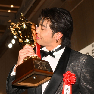トロフィーに口付けする武知海青(新人賞)